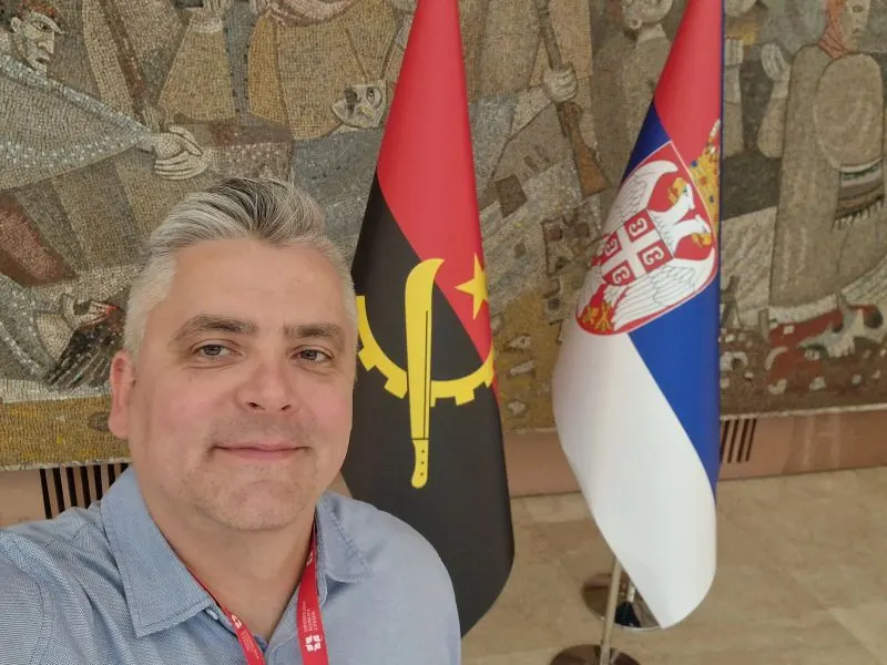 Ivan Jurčić next to the flags of Angola and Serbia