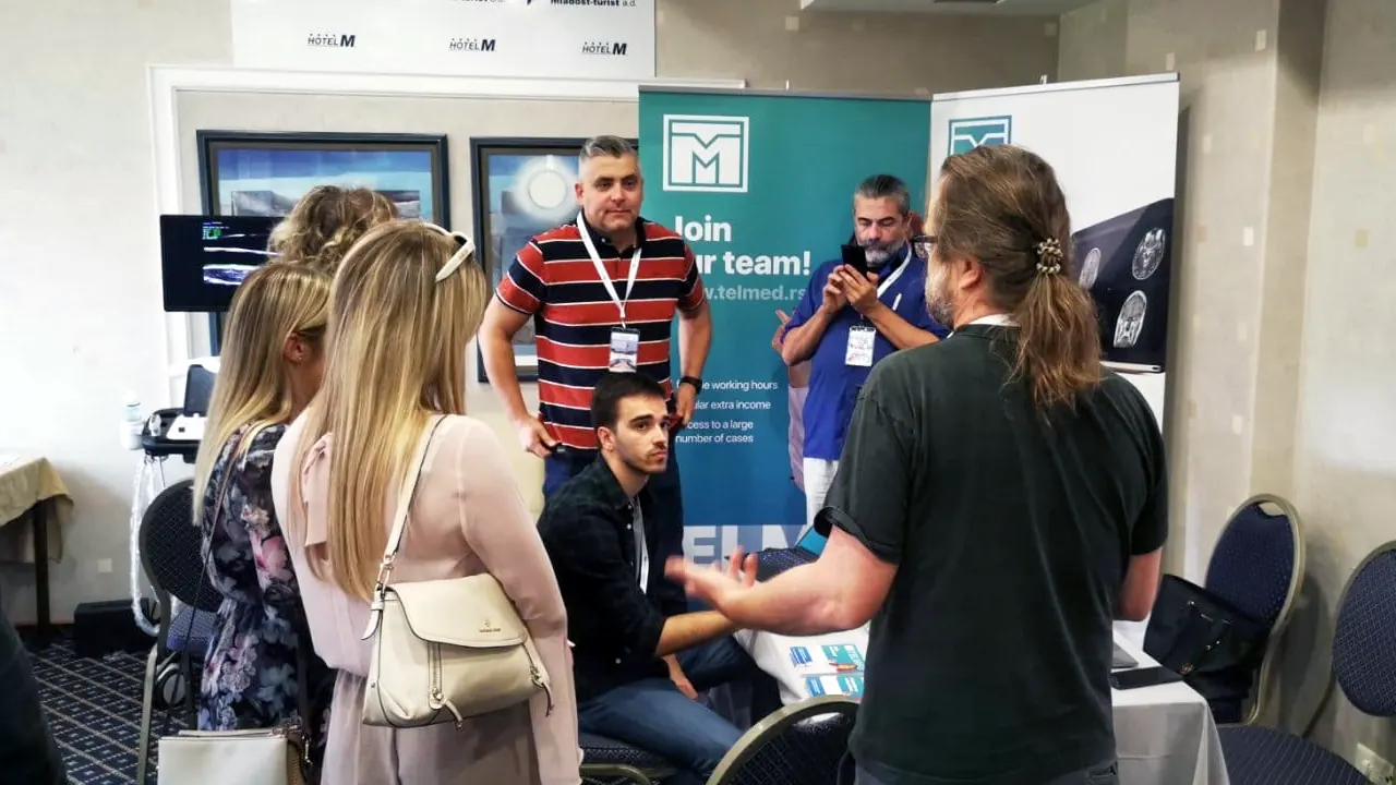 Conversation with radiologists in front of the “Join our team” banner